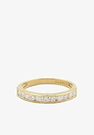 Złoty pierścionek z rzędem okrągłych przezroczystych kamieni na powierzchni, z gładką, wypolerowaną obrączką i minimalistycznym wzornictwem.