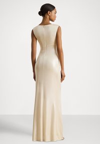 Langes, figurbetontes, ärmelloses Kleid in Champagnerfarbe mit glatter, glänzender Textur und einem dezenten Reißverschluss auf der Rückseite.