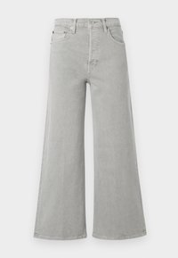 Jeans de mezclilla gris de pierna ancha con una alta cintura. Incluye bolsillos frontales, cremallera y detalles de hardware metálico en color marrón.