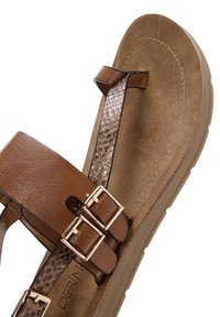 Sandalias marrones con suela plana, detalle de correa texturizada de piel de serpiente y acentos de doble hebilla. Forro interno suave con costuras mínimas.