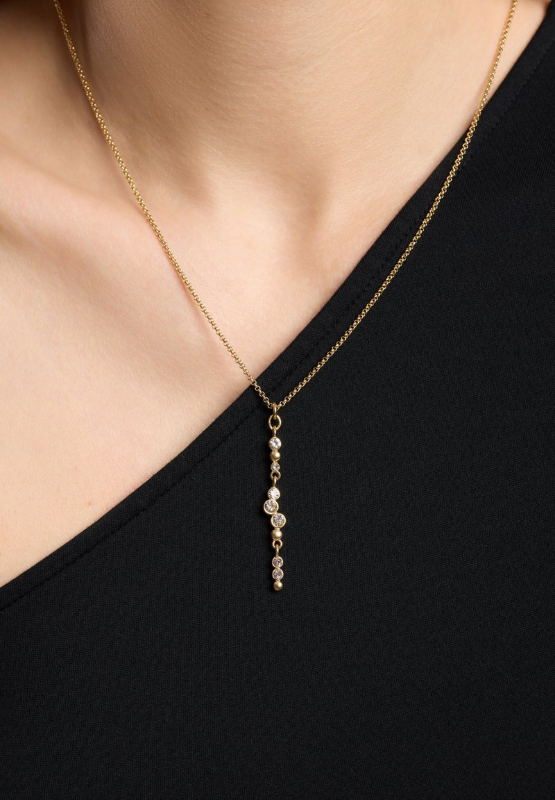 Gul vedhæng halskæde med en delikat kæde og et vertikalt dråbe-design, fremhævet af runde, glitrende sten.