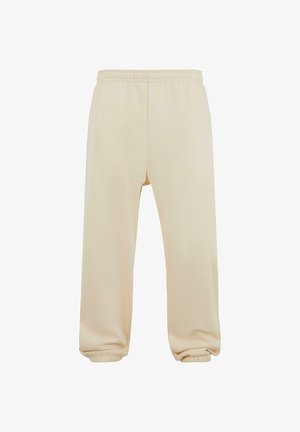 Pantaloni della tuta beige con vita elastica, orli a costina e superficie liscia. Design semplice a gamba dritta senza motivi o decorazioni.