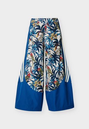 Pantalon à jambes larges avec des panneaux bleus et un tissu blanc imprimé d'oiseaux tropicaux colorés et de feuillage.