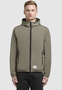 Khakifarbene Kapuzenjacke mit einem Frontreißverschluss, zwei seitlichen Taschen und elastischen Bündchen. Verfügt über ein Logopatch am Saum und eine glatte Textur.