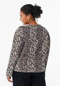 Leopard print sweatshirt made of soft fabric, featuring a round neck, long sleeves, and a relaxed fit. Dark brown and beige colors dominate.
