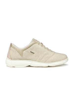 Baskets en tissu beige avec une texture douce, semelle en caoutchouc et design minimaliste. Présente un accent de talon beige clair et des détails de couture subtils.