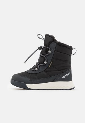 Botas isoladas pretas com parte superior texturizada, colarinho de pele sintética, atacadores elásticos e sola branca de borracha. Logótipo exibido na lateral.
