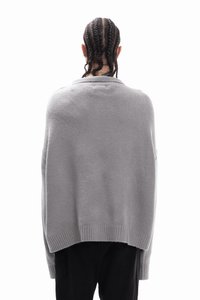 Grijze oversized trui met een zachte textuur, geribbelde zoom en verzonken schouders. De achterkant heeft een ronde halslijn en een losse pasvorm.