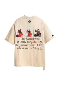 Camiseta de algodón beige con diseño gráfico. Presenta tres figuras de dibujos animados levantando pesas. El texto dice: "Cuanto más DUERMO por (MWM)...".