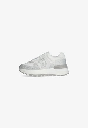 Scarpa atletica bianca con superiore in mesh testurizzato, dettagli argentati, chiusura con lacci e una robusta suola grigia con disegni antiscivolo.