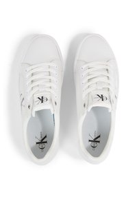 Baskets blanches avec une tige synthétique lisse, bout rond, design à lacets et un logo sur le côté. Semelle intérieure texturée et semelle extérieure en caoutchouc plate.