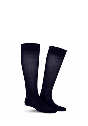 Paar schwarze knielange Socken, die auf weißem Hintergrund aufrecht stehen, glatte Textur, keine Muster oder Logos sichtbar.