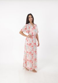 Robe maxi florale à manches courtes, ornée de fleurs roses, rouges et bleues sur un fond clair ; taille �élastique, design fluide.