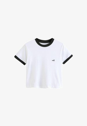 Biała koszulka z krótkim rękawem z czarnym ściągaczem przy kołnierzyku i mankietach. Na przodzie posiada małe logo z tekstem "self.".