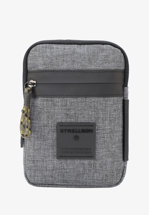 Funda de tela gris con un acabado texturizado, con una banda de cuero negro, un cierre de cremallera con un tirador trenzado y un parche con el logotipo.