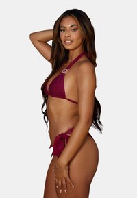 Burgundifärgad bikiniset med en triangulär topp med ringdetalj och knutna sidor på botten; texturerad tyg, halterneck-design.