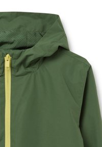 Grüne wasserdichte Jacke mit einer strukturierten Oberfläche, ausgestattet mit einem gelben Reißverschluss und einer Kapuze. Das Innere hat perforierte Details für Atmungsaktivität.