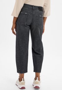 Donkergrijze denim jeans met een relaxte pasvorm, met een hoge taille, twee achterzakken en subtiele slijtage-details nabij de zakken.