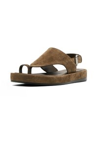 Sandales en suede marron avec une semelle plate, bout ouvert et une sangle à la cheville arrière. Présentent un design de découpes unique et un matériel minimaliste.