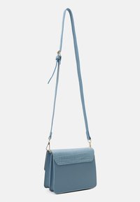 Jasnoniebieska torebka crossbody z syntetycznej skóry z teksturą krokodyla na klapie, regulowanym paskiem i złotymi akcentami.