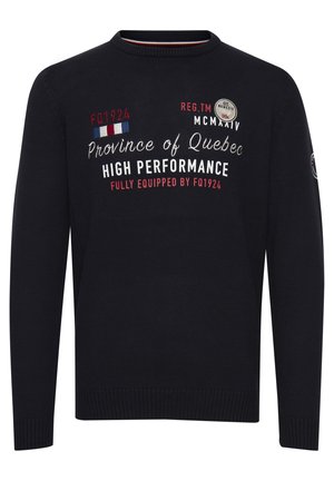 Čierny sveter s okrúhlym výstrihom. Obsahuje biele a červené tlačené texty a okrúhly nášivku s logom na ľavom rukáve. Žebrované manžety a lem.