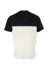 T-shirt a maniche corte con la parte superiore blu navy e la parte inferiore color crema. Realizzato in morbido cotone, con collo rotondo e un design di color blocking sottile.