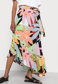 Roestig-gepatteerde, asymmetrische rok in pastelkleuren met een zwarte basis, gemaakt van lichtgewicht stof, met een gestrikt middel en een gerimpelde onderkant.