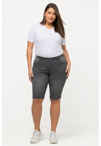 Shorts en denim gris avec une taille ajustée et cinq poches, associés à un t-shirt blanc à col en V et des baskets blanches.