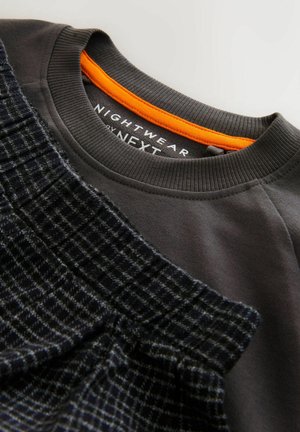 Šedá mikina s texturovanou tmavě šedou vzorovanou vrstvou. Má oranžový akcent na výstřihu; štítek čte "NIGHTWEAR by NEXT."