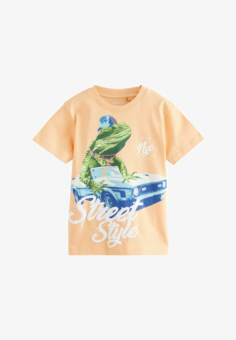 Peach-colored short-sleeve shirt with graphic of a green lizard wearing a blue cap and pink necklace, leaning on a blue car with "Street Style" text.