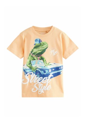 Bavlněné tričko, broskvové barvy, s grafikou zelené ještěrky v kšiltovce na modrém autě, s nápisem "Street Style" vytištěným bílou barvou.