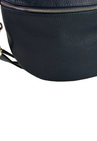 Donkerblauwe leren tas met een gestructureerde afwerking, afgeronde vorm en zilverkleurige ritssluiting, voorzien van een verstelbare band voor veelzijdig draaggemak.