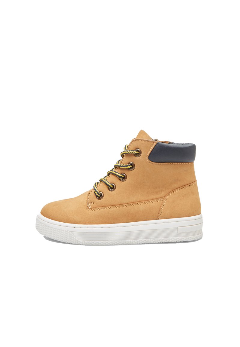 Zapato alto de cuero marrón claro con suela de goma blanca, cordones amarillos y negros, y un acento en el tobillo de color azul marino. Textura suave, diseño minimalista.