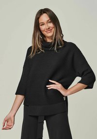 Schwarzer Rippstrickpullover mit einem Kragen, 3/4-Ärmeln und einer lockeren Passform. Mit seitlichem Schlitz und subtiler Labeldetails am Saum.