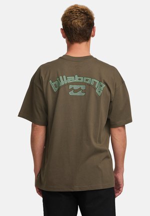 Olive green oversized t-shirt featuring white and teal "Billabong" logo and wave design on back. Made of soft, breathable fabric.