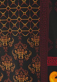 Black fabric with intricate patterns in gold and orange, featuring geometric shapes, florals, and decorative borders in red.