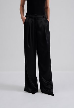 Schwarze Satin-Hose mit weitem Bein, Frontfalten, seitlichen Taschen und einer glatten Textur, entworfen für eine lockere Passform.