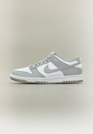 Low-top Nike sneaker in white and light grey with perforated toe, lace-up closure, and signature swoosh on a neutral background.