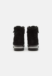 Schwarze Wildleder-Stiefeletten mit einem gesteppten Muster, einer glatten grauen Sohle und goldenen Reißverschlüssen hinten für einen einfachen Zugang.