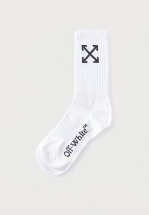 Weißer, gerippter Sneakersocken mit schwarzem Off-White-Logo-Schriftzug auf dem Fuß und einem schwarzen vierpfeiligen Kreuzsymbol nahe dem oberen Rand.