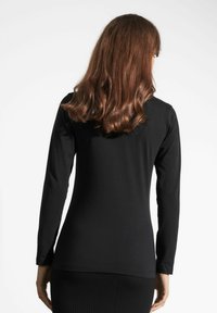 Czarna bluzka z długim rękawem wykonana z gładkiego materiału, charakteryzująca się prostym fasonem, okrągłym dekoltem i dopasowanym krojem.