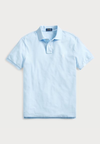 Polo de cor azul clara feito de algodão, com mangas curtas, colarinho dobrado e fecho de três botões. Apresenta um pequeno logótipo bordado no peito.