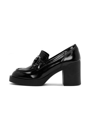 Mocasín de mujer de charol negro con tacón de bloque y hebilla decorativa en la parte superior, mostrado de lado sobre fondo blanco.