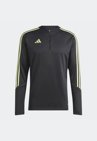Black long-sleeve athletic top with zip neck, featuring yellow diagonal stripes on shoulders and Adidas logo on the upper left chest.
