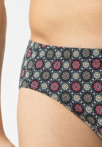 Baumwollbikiniunterhose mit dunklem Hintergrund, versehen mit einem geometrischen Blumenmuster in Rot, Grün und Weiß; mittlere Leibhöhe.