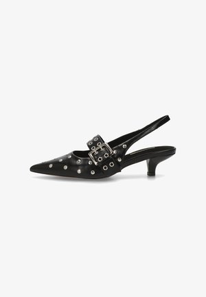 Zapato de tacón slingback de cuero negro con punta afilada, acentos de tachuelas plateadas y una hebilla decorativa. Presenta un pequeño tacón de gato para mayor altura.
