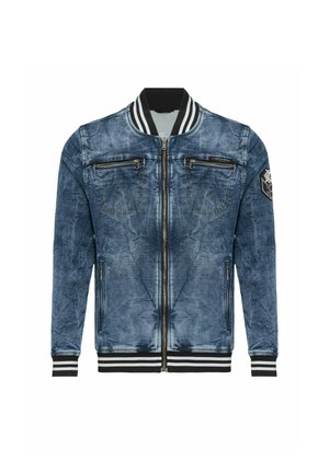 Veste bomber en denim bleu avec col, poignets et ourlet côtelés rayés noir et blanc, fermeture éclair devant, poches poitrine et latérales zippées, et patch sur la manche gauche.