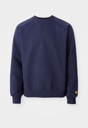Navy blue sweatshirt with a crew neck, ribbed cuffs, and hem. Features a small yellow logo on the left wrist. Soft texture, casual design.