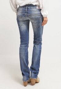 Jeans i lätt blått med en blekt finish. Har fem fickor, bältesloopar och en rak ben-design. Texturerad tyg med sömdetaljer.