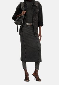 Jeansoutfit i svart, med en jacka, figursydd klänning och cropped byxor. Väskan med kedjedetaljer och remsandaler fulländar looken.